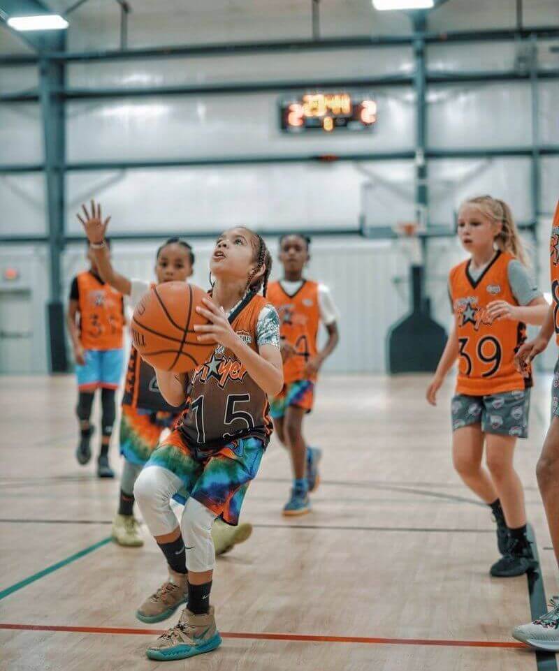 student girls playing basketball as a team on the indoor court at created player gym